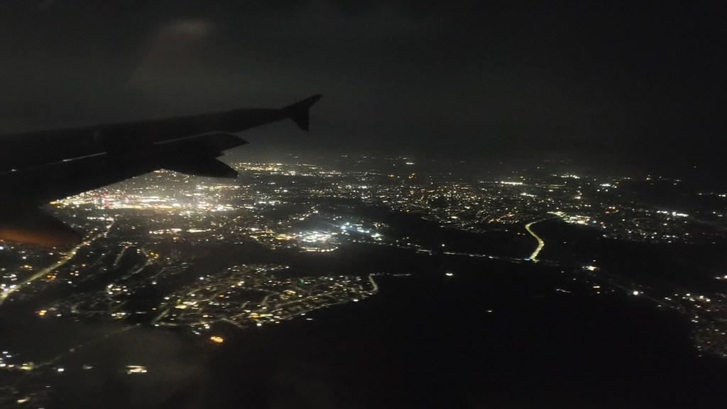 Night time flight over Lisbon, Portugal with all the buildings and streets lit up beautifully.
