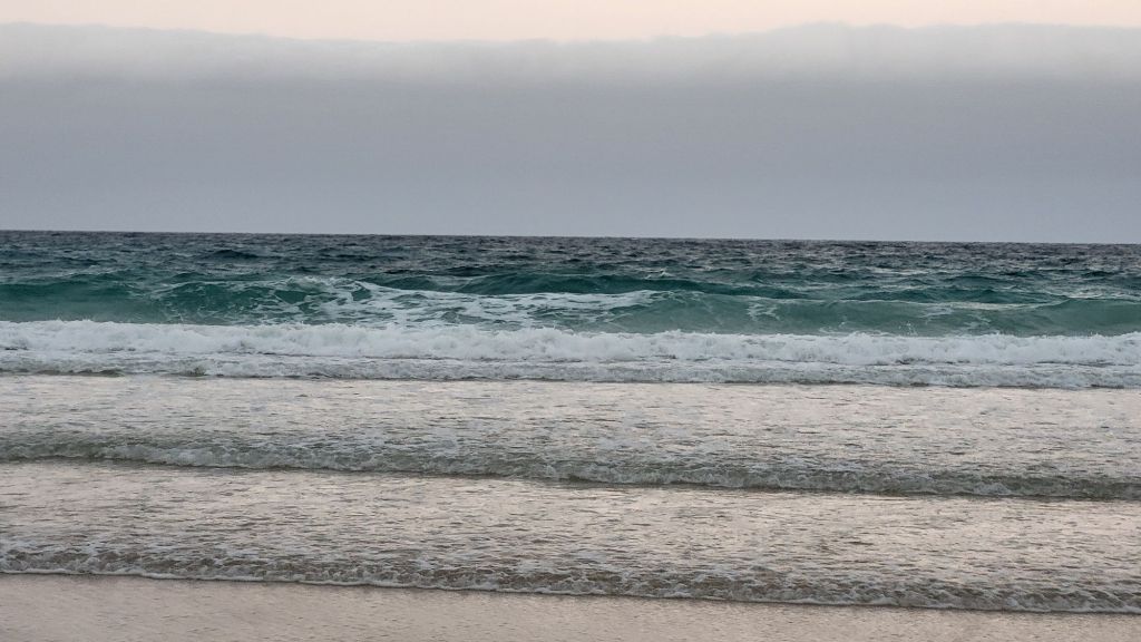A landscape photo of the waves gently rolling in at Grandes Playas Beach, Corralejo.