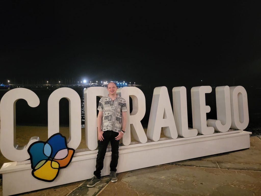Steve stood in front of a large Corralejo sign.